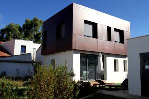 a white and black building with a table and a umbrella at Casa Oretani in Picón