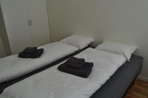 duas camas com toalhas por cima num quarto em Utsira Overnatting - Bølgen em Utsira