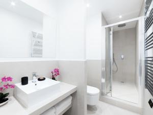 a white bathroom with a sink and a shower at LivinParis - Luxury 3 & 4 Bedrooms Montmartre I in Paris