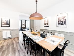 una sala da pranzo con un grande tavolo in legno e sedie nere di LivinParis - Luxury 3 & 4 Bedrooms Montmartre I a Parigi