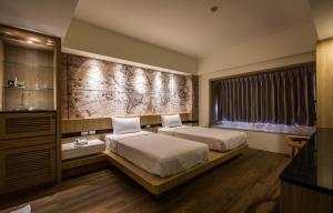 pokój hotelowy z 2 łóżkami i oknem w obiekcie YHC Hotel w mieście Tainan