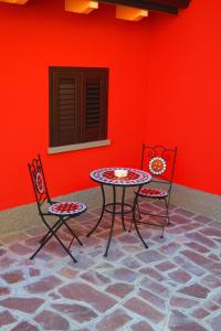 einen Tisch und zwei Stühle vor einer roten Wand in der Unterkunft CaMé in Alzano Lombardo