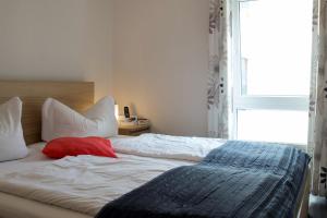 a bedroom with two beds and a window at Hotel Am Theaterplatz in Bremerhaven