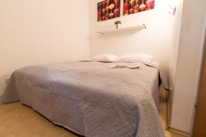 sypialnia z łóżkiem z szarą kołdrą w obiekcie Apartmenthaus Hietzing I contactless check-in w Wiedniu