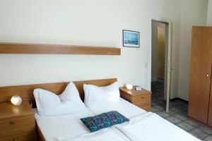 a bedroom with a bed with white sheets and pillows at Hotel Am Theaterplatz in Bremerhaven +23 photos