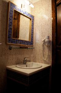 y baño con lavabo y espejo. en Petrini Gonia, en Livadero