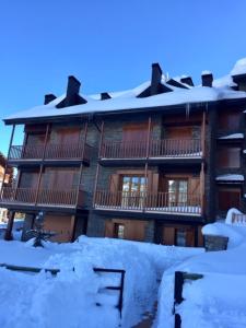 a large building with snow in front of it at Apartamento frente Pistas de Esquí La Molina in La Molina