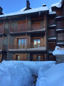 a building with snow on the ground in front of it at Apartamento frente Pistas de Esquí La Molina in La Molina