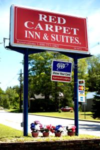 una señal para una posada de alfombras rojas y suites en Red Carpet Inn and Suites Plymouth, en Plymouth