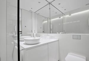 a white bathroom with two sinks and a mirror at Andersia Park in Poznań +21 photos