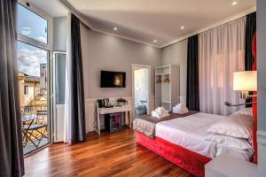 a hotel room with a bed and a balcony at La Foresteria Luxury Suites in Rome