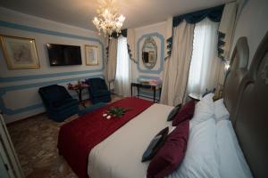 a bedroom with a large bed and a chandelier at Ca' Dell' Arte Luxury in Venice