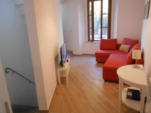 a living room with a red couch and a tv at CIVICO 47 in Pisa