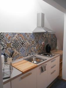 cocina con fregadero y pared de azulejos en CIVICO 47 en Pisa