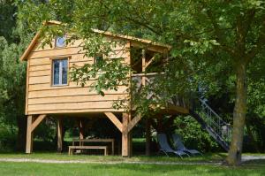 a tree house with a table and chairs in front of it at LES GITES INSOLITES DE LA CASCADE in Lespesses