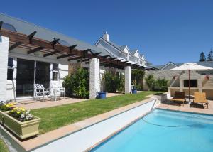 a backyard with a swimming pool and a pergola at The Gables Hermanus in Hermanus
