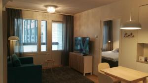a living room with a tv and a room with a bed at RovaVisit Apartments Siljo in Rovaniemi