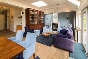 a living room with blue chairs and a table at Burgers & Buitenlui in Diever