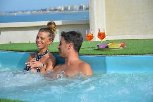 a man and a woman sitting in a hot tub at AmbientHotels Panoramic in Rimini