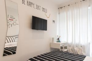 um quarto com uma cama e uma televisão na parede em Eden guest house em Roma