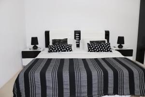 a bedroom with a large bed with black and white stripes at Mahina Sunset Heights in Flic-en-Flac