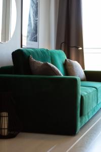 a green couch sitting in a living room at Baltic Apartments Seaside Towers in Gdańsk