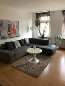 Süd-Apartments في لايبزيغ: غرفة معيشة مع أريكة وطاولة