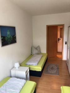 a room with two beds and a tv on the wall at Süd-Apartments in Leipzig