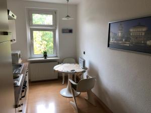 Süd-Apartments في لايبزيغ: مطبخ مع طاولة وكراسي في غرفة