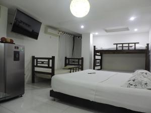 サンタ・マルタにあるApartahotel Dorado Rodaderoのベッドと薄型テレビのある寝室