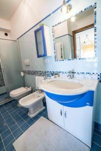a bathroom with a sink and a toilet and a mirror at Villa Sofia in Taormina
