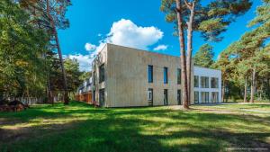 an exterior view of a building with trees at OW Posejdon Dźwirzyno in Dźwirzyno