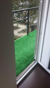 una ventana con vista a un patio verde en Buşteni House, en Buşteni