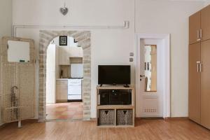 a living room with a television and a kitchen at Apartment Caffé Latte in Budapest