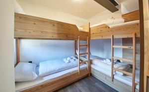 two bunk beds in a room with wooden walls at Time for Sport Apartments in Saalbach-Hinterglemm