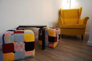 a room with a table and a yellow chair at Stylish house - air cond, breakfast, free parking in Vila Nova de Gaia