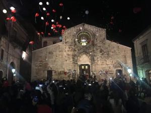 a crowd of people standing in front of a building with a clock at Dormire nel Borgo in Bovino