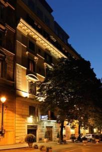 un edificio alto con un árbol delante de él en Hotel Eliseo, en Roma