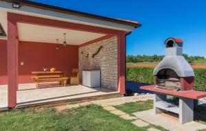 a patio with a pizza oven in front of a house at Villa Kata in Rebići