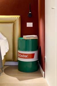 a green and white barrel with books on top of it at OFFICINA TESINI Guest Rooms Verona in Verona