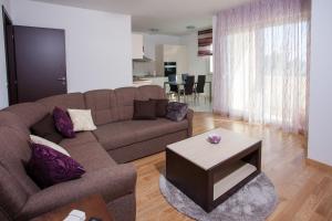 sala de estar con sofá marrón y mesa en Luxury Vesna Apartments, en Kaštela