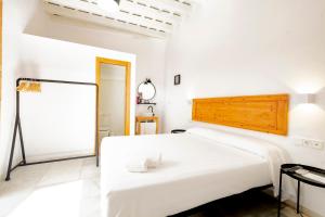a white bedroom with a large bed and a mirror at Bekkeh Posada Boutique in Vejer de la Frontera