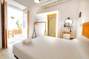 a bedroom with a large white bed with towels on it at Bekkeh Posada Boutique in Vejer de la Frontera