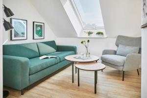 a living room with a green couch and a table at Glücksferien- Gänseblümchen in Glücksburg