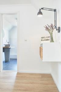 a white bathroom with a sink and a mirror at Glücksferien- Gänseblümchen in Glücksburg +15 photos