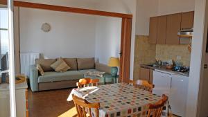 uma cozinha e sala de estar com uma mesa e um sofá em Appartamenti La Pineta em Marina dʼAndora