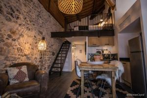 a kitchen with a table and a loft at Demeure Terrisse La Résidence in Marseillan