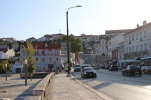 a busy city street with cars driving down the road at Guest House Santa Clara in Coimbra