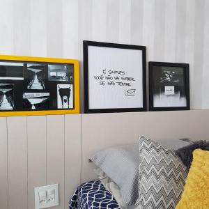 three pictures on a wall above a bed in a bedroom at Praia Grande Arraial do Cabo in Arraial do Cabo