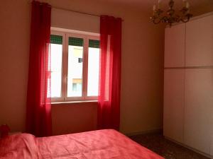 a bedroom with a bed and a window with red curtains at Diamante in Sorrento